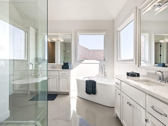 bathroom featuring plus walk in shower, vanity, tile patterned floors, and lofted ceiling