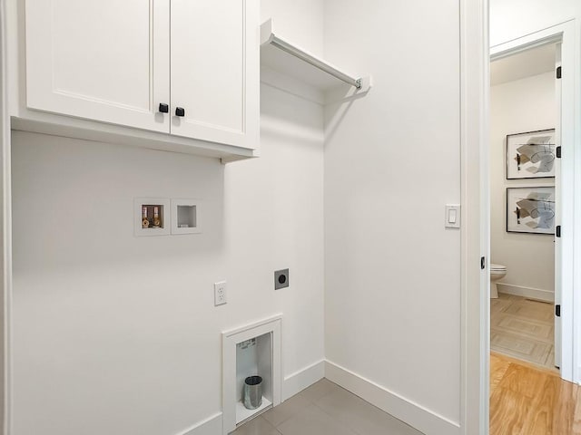 washroom with hookup for a washing machine, cabinets, and hookup for an electric dryer