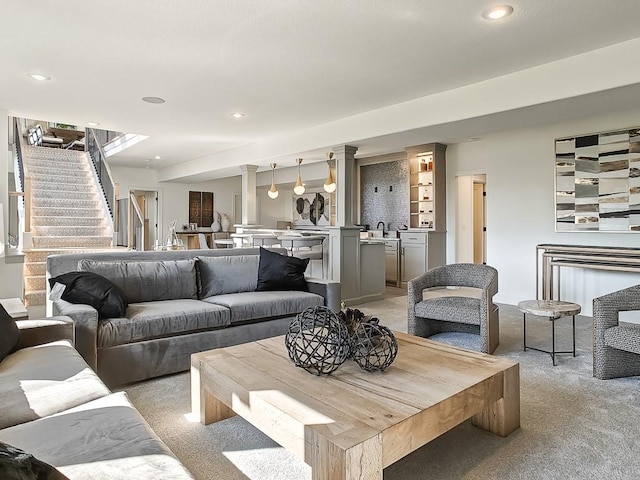 living room featuring sink and light colored carpet