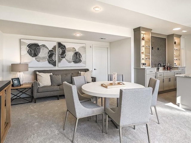 carpeted dining space with sink