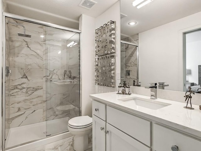 bathroom featuring vanity, toilet, and a shower with door