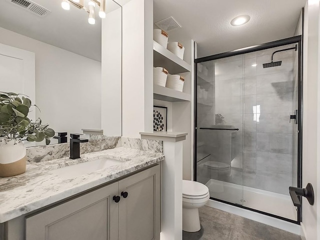 bathroom featuring tile patterned flooring, vanity, an enclosed shower, and toilet