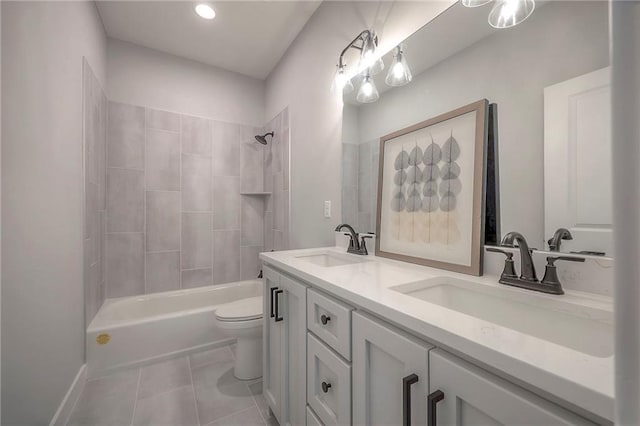 bathroom featuring tile patterned flooring, double vanity, toilet, and a sink