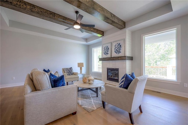 living room with plenty of natural light, light wood-style floors, and baseboards