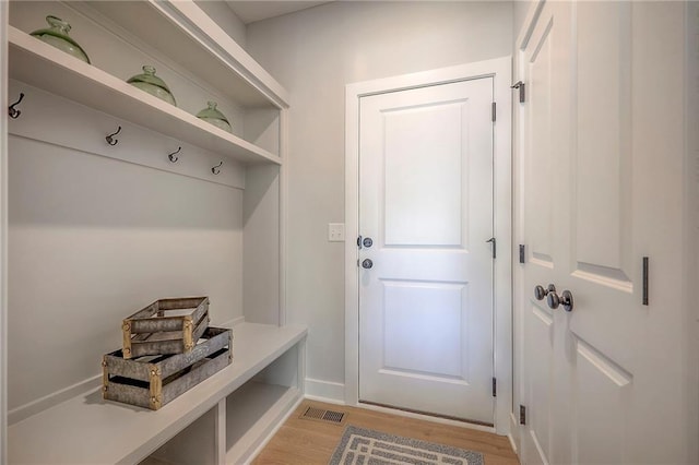 mudroom with visible vents, baseboards, and light wood-style floors