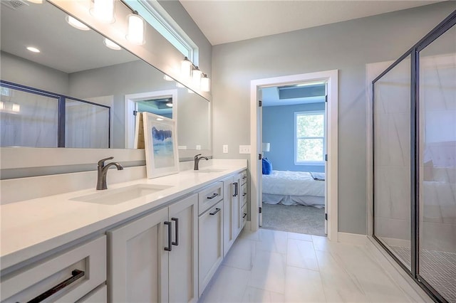 full bathroom featuring double vanity, a shower stall, connected bathroom, and a sink