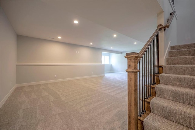 below grade area featuring recessed lighting, baseboards, light carpet, and stairs