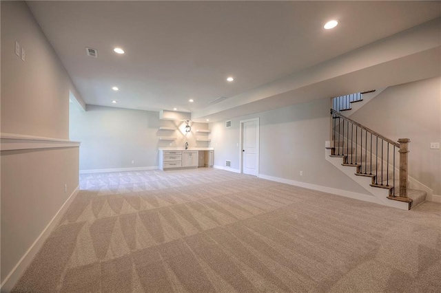 unfurnished living room with stairway, recessed lighting, baseboards, and light carpet