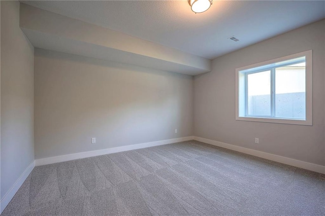 carpeted spare room with baseboards and visible vents