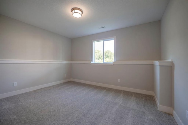 unfurnished room featuring visible vents, baseboards, and carpet
