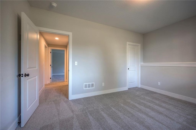 unfurnished bedroom featuring baseboards, visible vents, and carpet floors