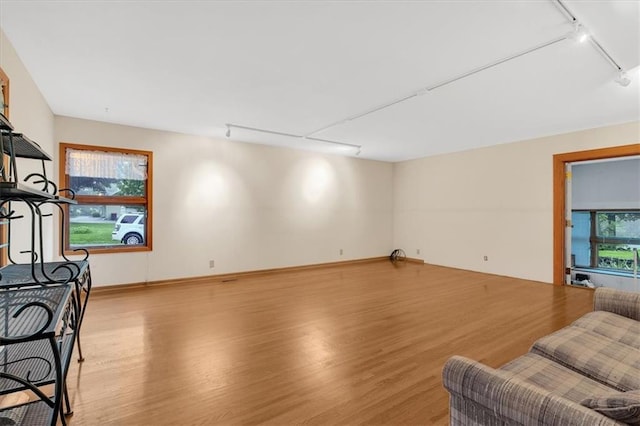 living room featuring a healthy amount of sunlight, track lighting, and light wood-type flooring