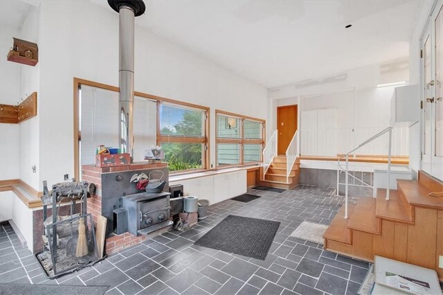 miscellaneous room featuring a wood stove and dark tile patterned flooring