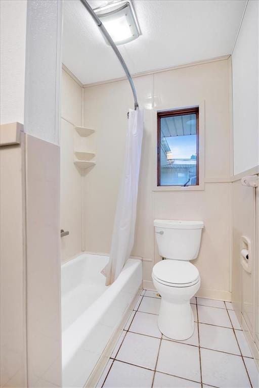 bathroom featuring shower / tub combo, tile patterned flooring, and toilet