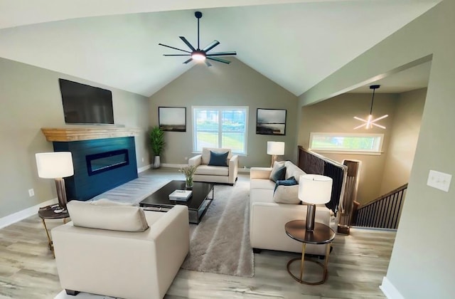 living room with ceiling fan with notable chandelier, high vaulted ceiling, and wood-type flooring