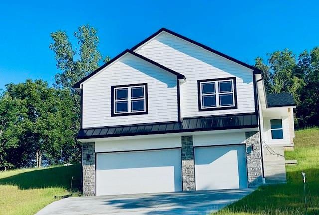 view of side of home with metal roof, an attached garage, stone siding, concrete driveway, and a standing seam roof