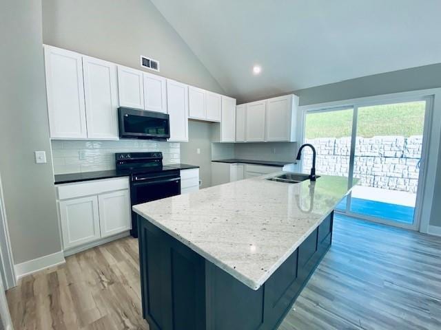 kitchen featuring a sink, visible vents, white cabinets, black electric range oven, and stainless steel microwave