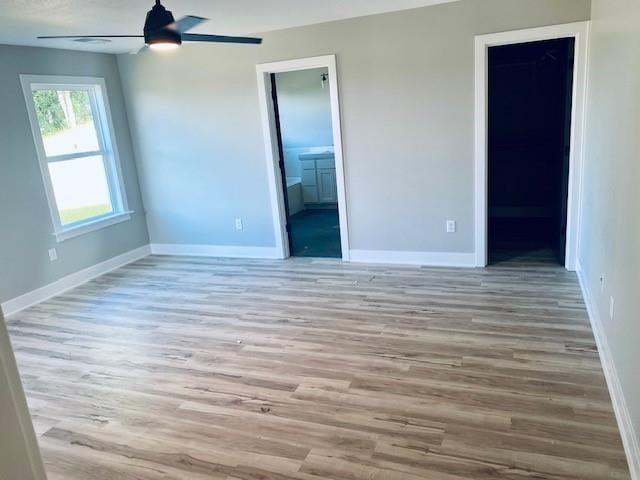 unfurnished room featuring ceiling fan, baseboards, and wood finished floors