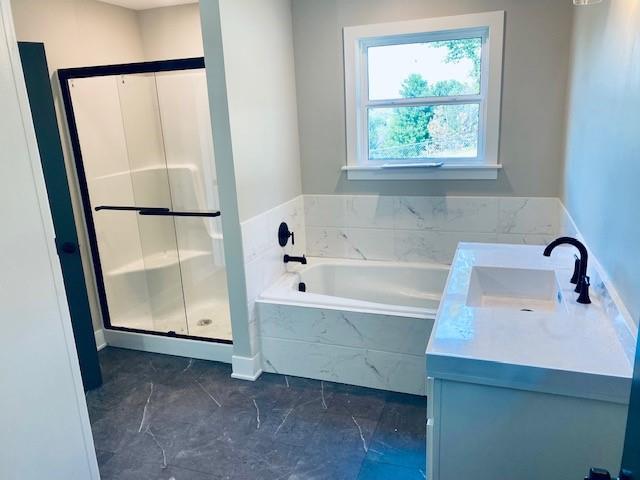 full bathroom featuring a shower stall, vanity, and a bath