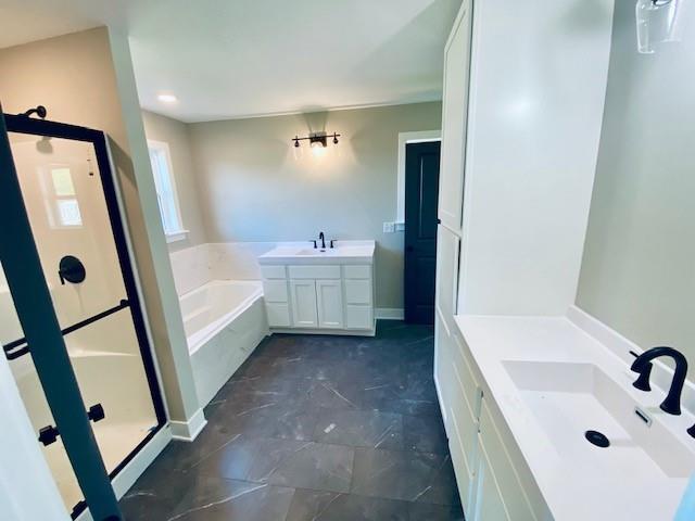 bathroom with a garden tub, vanity, and a shower stall