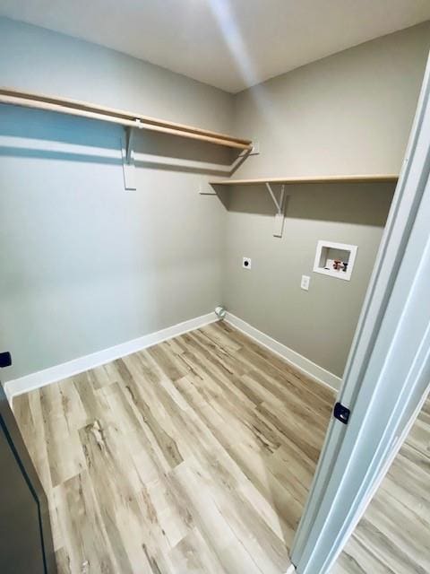 washroom with laundry area, washer hookup, light wood-type flooring, and baseboards