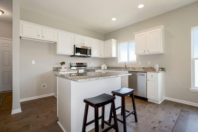 kitchen with light wood-type flooring, stainless steel appliances, and white cabinetry