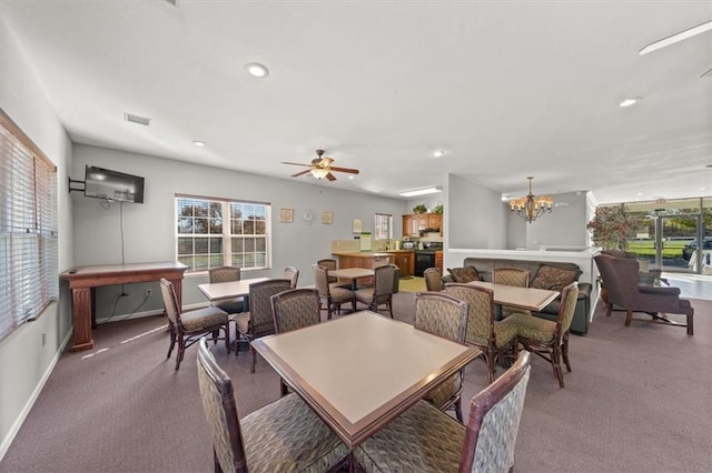 dining space featuring ceiling fan with notable chandelier and carpet floors