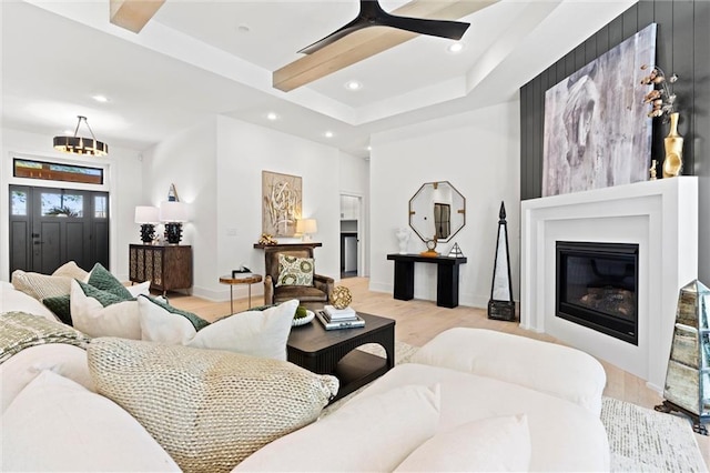 living room featuring a tray ceiling, light hardwood / wood-style floors, and ceiling fan