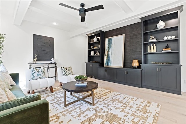 living room with light wood-type flooring, beam ceiling, ceiling fan, and built in features