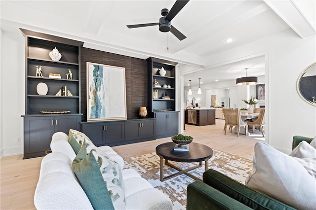 living room with beamed ceiling, ceiling fan, and light hardwood / wood-style flooring