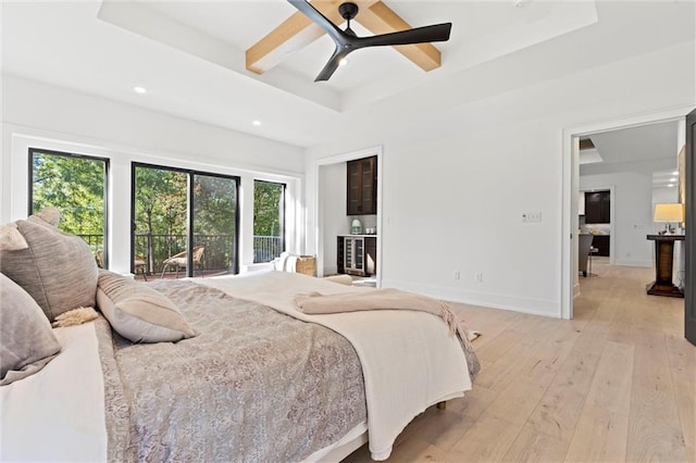 bedroom with light hardwood / wood-style flooring, ceiling fan, a raised ceiling, and access to exterior