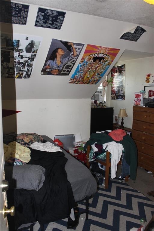 bedroom with carpet floors and a textured ceiling