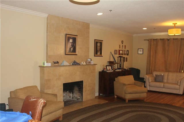 living room featuring tile walls, ornamental molding, dark hardwood / wood-style floors, and a tiled fireplace