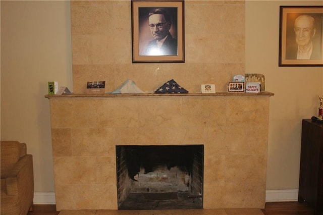 interior details featuring a tile fireplace and dark hardwood / wood-style floors