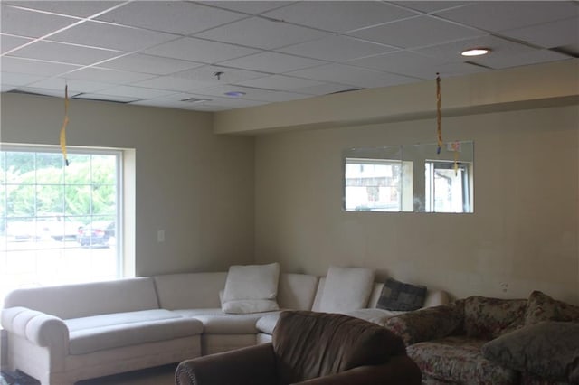 living room featuring a drop ceiling and a wealth of natural light