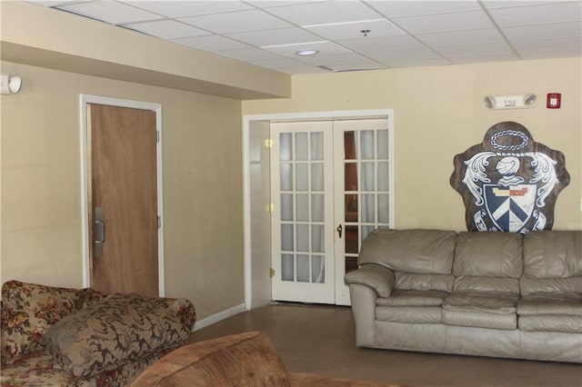 living room featuring a paneled ceiling and french doors