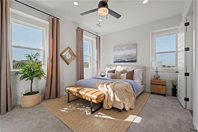 carpeted bedroom with multiple windows and ceiling fan