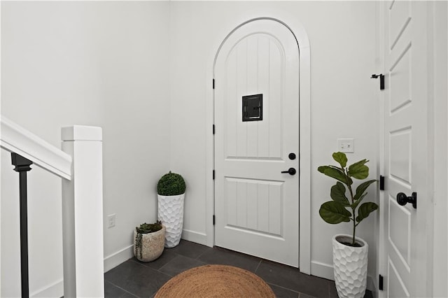 entryway with electric panel and dark tile patterned floors