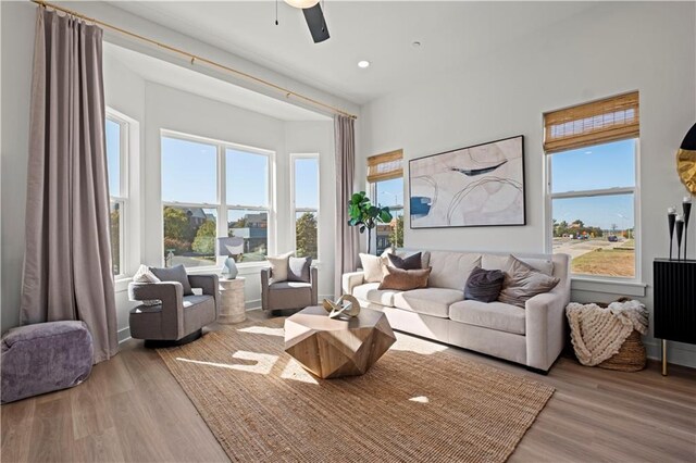 living room with light hardwood / wood-style floors and ceiling fan