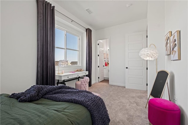 bedroom featuring light carpet and ensuite bathroom