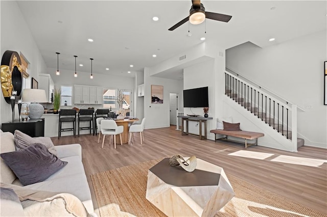 living room with light hardwood / wood-style flooring and ceiling fan