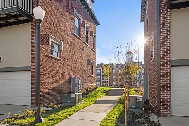 view of side of property featuring central air condition unit and a garage