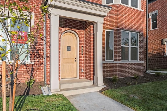 property entrance featuring a lawn