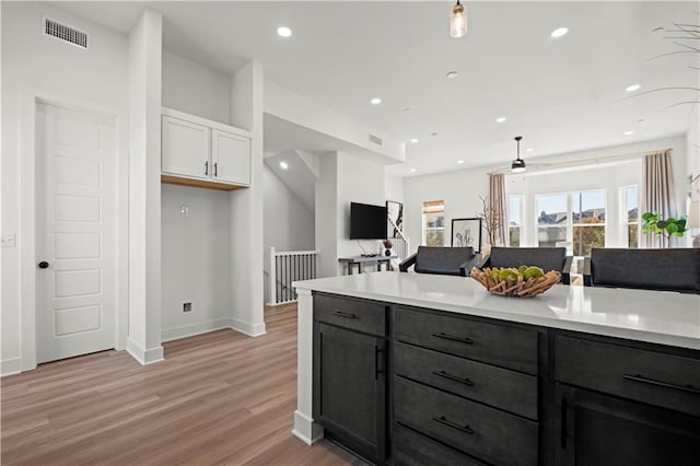 kitchen with light hardwood / wood-style flooring, white cabinets, and ceiling fan