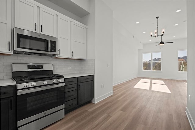 kitchen featuring backsplash, appliances with stainless steel finishes, light wood-type flooring, and white cabinets