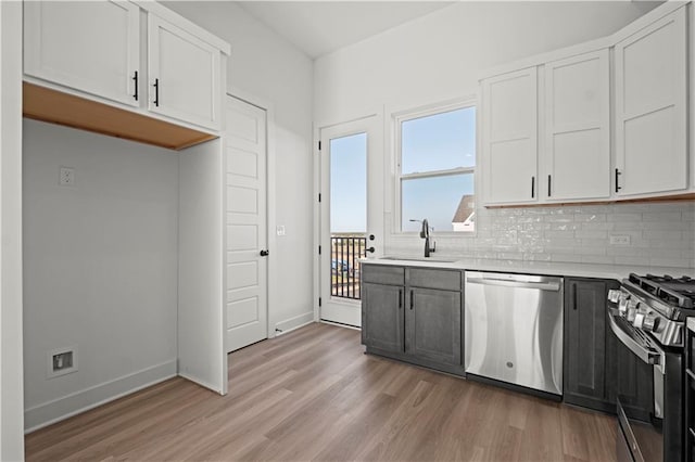 kitchen with sink, white cabinetry, stainless steel appliances, and light hardwood / wood-style floors