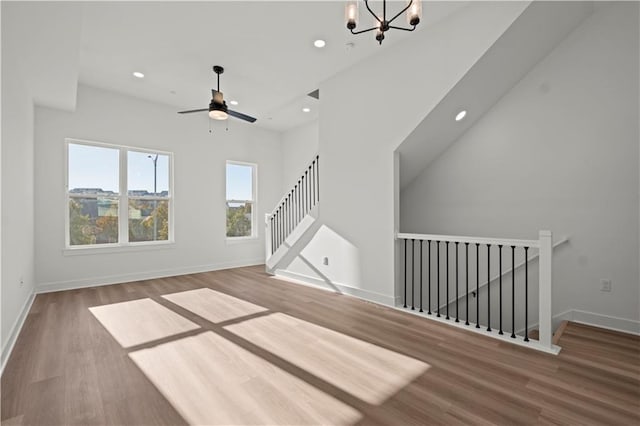 interior space featuring wood-type flooring and ceiling fan with notable chandelier