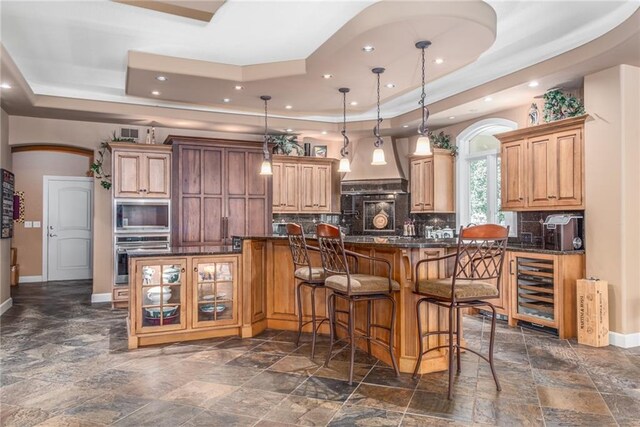 1709 Lake Alvamar Dr, Lawrence, KS 66047 - kitchen with a tray ceiling, baseboards, tasteful backsplash, and custom exhaust hood