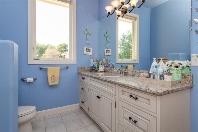 1709 Lake Alvamar Dr, Lawrence, KS 66047 - bathroom featuring an inviting chandelier, toilet, tile patterned floors, baseboards, and vanity