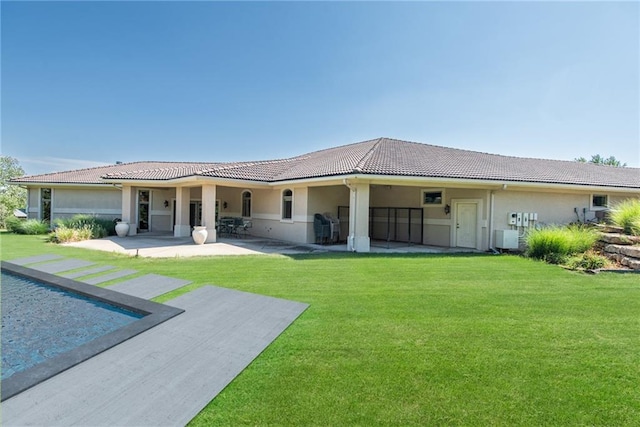 1709 Lake Alvamar Dr, Lawrence, KS 66047 - rear view of property with a lawn, stucco siding, a tiled roof, and a patio